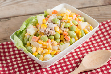 Tuna corn salad in white bowl.
