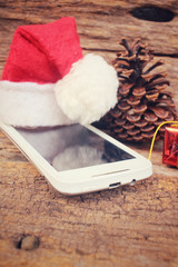 Smart phone and gift with christmas hat