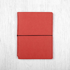 red notebook on white wooden table, top view
