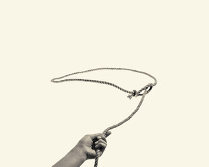 The hand throws a lasso on toned background - obrazy, fototapety, plakaty