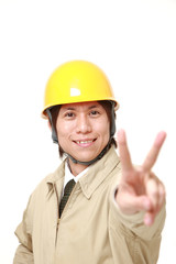 young Japanese construction worker showing a victory sign