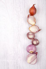 red onion bulb on white wood table