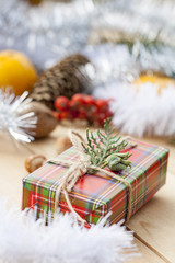 Christmas gift box with New Year's and Christmas decoration midst fruits and tinsel.