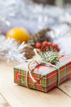 Christmas gift box with New Year's and Christmas decoration midst fruits and tinsel.