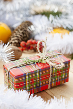 Christmas gift box with New Year's and Christmas decoration midst fruits and tinsel.