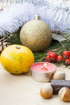 Christmas red candle on wooden table among Christmas and New Year ball and decor