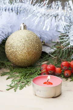 Christmas red candle on wooden table among Christmas and New Year ball and decor