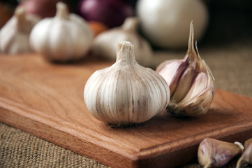 Garlic on cutting board , close-up on sacking. burlap background