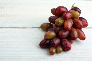 Grona grapes on a white wooden background