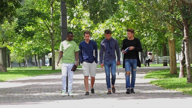 College men students walking together on campus. slow motion