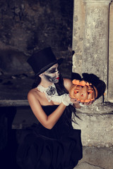 Beautiful witch making the witchcraft over the smoky background. Halloween image.