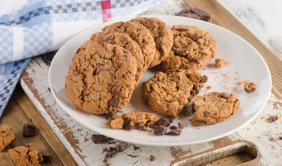 Chocolate chip cookies on white wooden board.