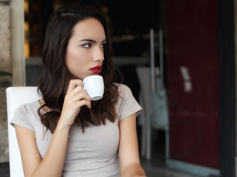 Girl sitting in cafe drinking coffee