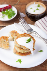 Fried potato pancakes with oatmeal and basil on a white ceramic plate.