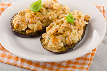 Baked eggplant with chanterelles on white plate.