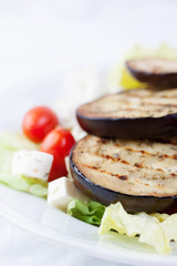 .Salad with grilled eggplants, tomatoes, feta cheese and lettuce. Closeup.