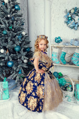 Happy small girl in dress with present have a christmas. Happy little girl holding gift box by...