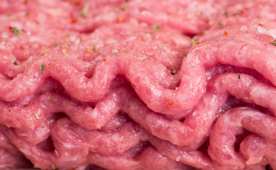 Minced meat with spices on wooden board. macro photo
