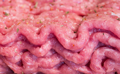 Minced meat with spices on wooden board. macro photo