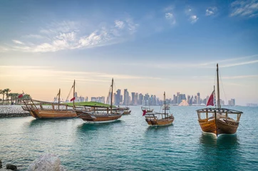 Fototapeten Dhows moored off Museum Park in central Doha, Qatar, Arabia, with some of the buildings from the city's commercial port in the background. © matpit73