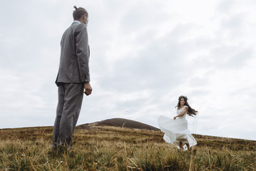 Obraz premium beautiful stylish groom and fabulous happy emotional bride and h