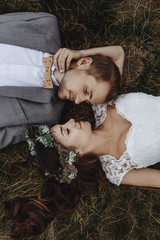 beautiful fabulous happy  bride and stylish groom lying down on
