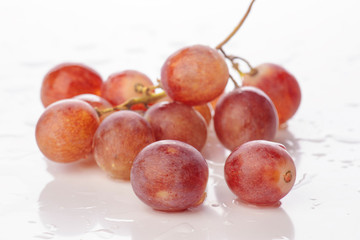 bunch of grapes in white base with water droplets wet
