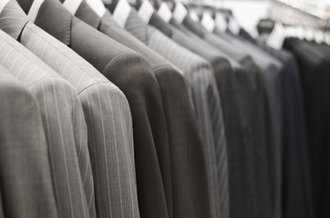 Men suits hanging in a clothing store.