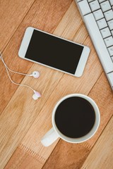 Black smartphone with cup of coffee