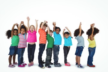 Group of kids standing in a line with raised arms