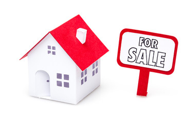 Little paper house with a for sale sign