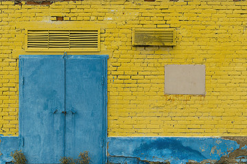 Naklejka premium yellow brick wall with blue door