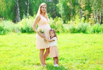 Naklejka na ściany i meble Happy pregnant woman, mother and little child daughter with cham