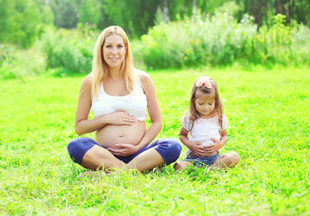 Fototapeta premium Happy pregnant woman, mother and little daughter child sitting o