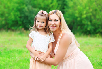 Fototapeta premium Portrait happy mother and daughter child together in summer day