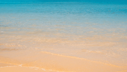 Fototapeta na wymiar Bright orange sand and blue sea