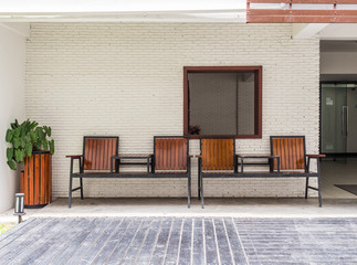 Fototapeta premium Wooden chairs against brick wall