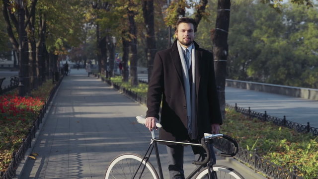 young businessman standing with bicycle