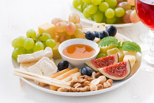 cheeses, fruits, wine and snacks, closeup