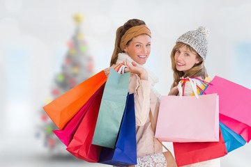 Composite image of beautiful women holding shopping bags
