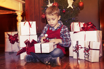 lovely little boy opens a christmas gifts