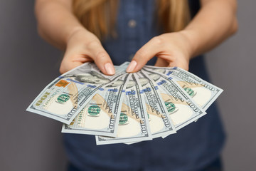 Fan of 100 dollar banknotes in woman hands