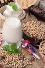 Soy milk and soybeans on wood background.