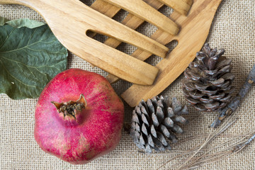 Pomegranate, pine cones and wooden utensils