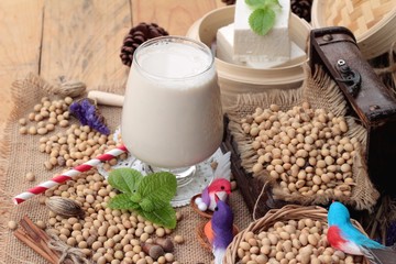 Soy milk and soybeans on wood background.