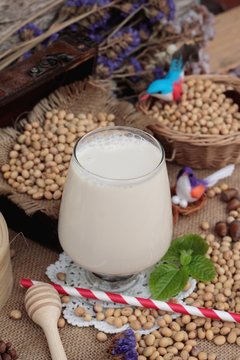 Soy milk and soybeans on wood background.