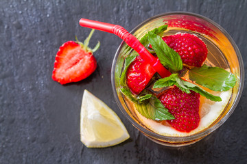 Strawberry lemonade ingredients with mint, dark stone background