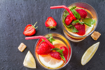 Strawberry lemonade ingredients with mint, dark stone background