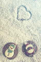 Fototapeta premium Christmas frame with chocolate figures on a snowy background