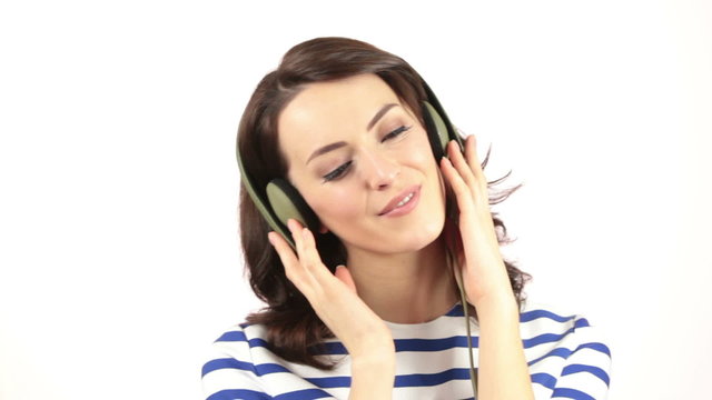 Attractive young woman listening to music through headphones and dancing